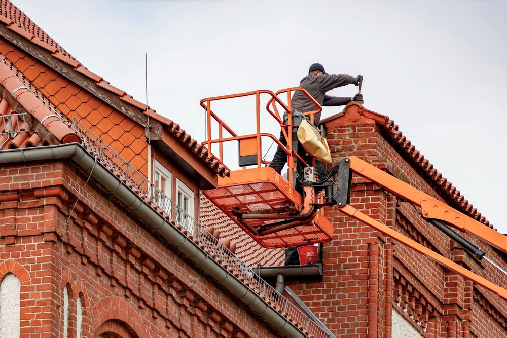 Roofer on a lift servicing the roof of a commercial building