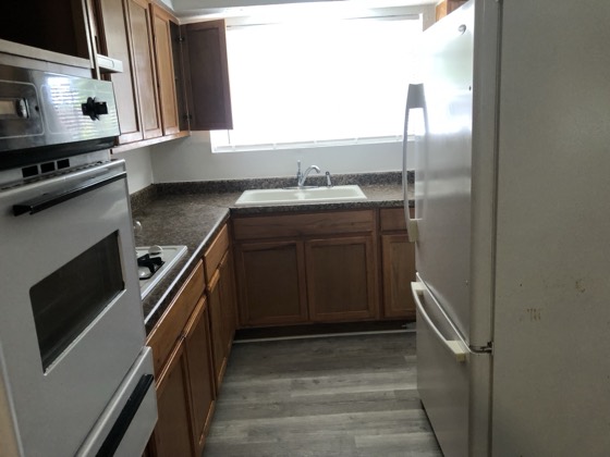 Bright finished kitchen with stainless fridge and new counters — AttarCo Homes roofing & remodeling project, Houston TX