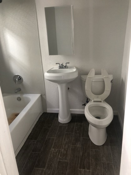 Finished bathroom with new pedestal sink and tile floor — AttarCo Homes roofing & remodeling project, Houston TX