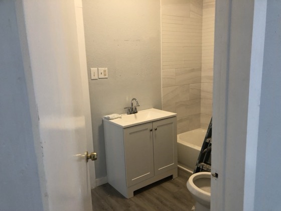 Finished bathroom with new vanity and tiled tub surround — AttarCo Homes roofing & remodeling project, Houston TX