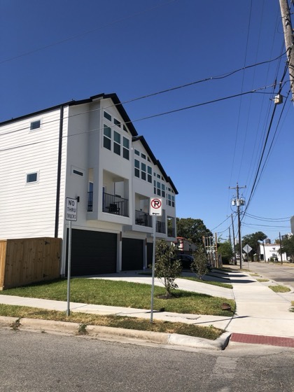 Finished modern white three-story townhome on corner lot — AttarCo Homes roofing & remodeling project, Houston TX