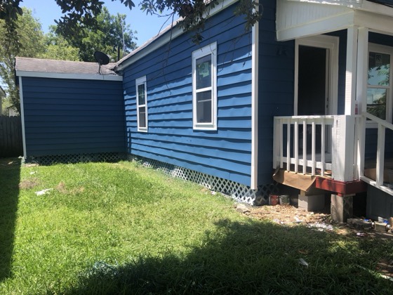 Finished navy siding with clean side yard — AttarCo Homes roofing & remodeling project, Houston TX
