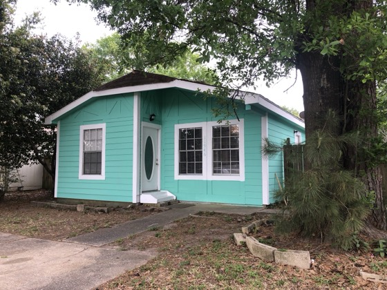 Freshly painted teal cottage with crisp white trim — AttarCo Homes roofing & remodeling project, Houston TX