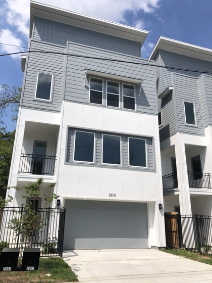 Modern three-story townhome front facade — AttarCo Homes roofing & remodeling project, Houston TX