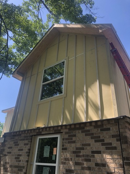 New board-and-batten siding and brick gable end — AttarCo Homes roofing & remodeling project, Houston TX