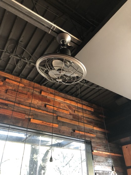 Reclaimed wood accent wall with vintage cage fan — AttarCo Homes roofing & remodeling project, Houston TX