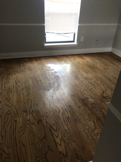 Refinished red oak floors in bright bedroom — AttarCo Homes roofing & remodeling project, Houston TX