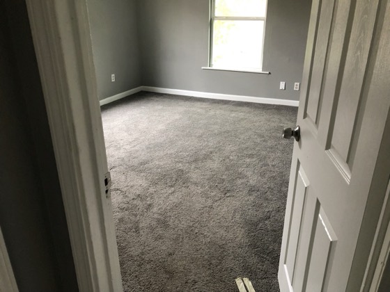 Renovated bedroom with dark wood floors and fresh paint — AttarCo Homes roofing & remodeling project, Houston TX