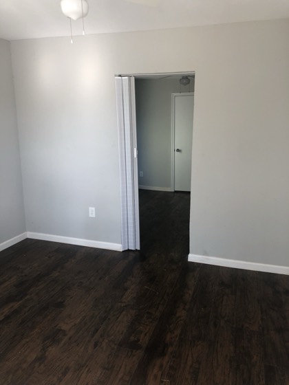 Renovated bedroom with new dark wood flooring — AttarCo Homes roofing & remodeling project, Houston TX