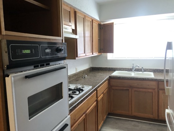 Renovated kitchen with wood cabinets and new appliances — AttarCo Homes roofing & remodeling project, Houston TX