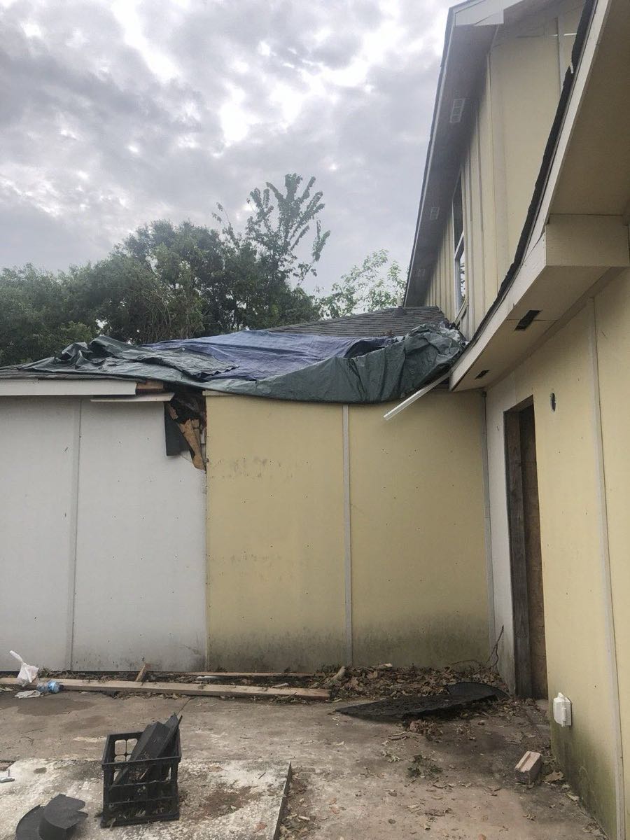 Emergency tarp over a damaged roof section — AttarCo Homes wind damage roof repair in Houston, TX